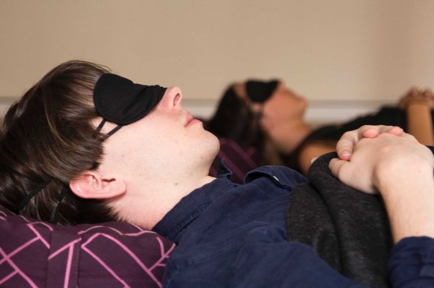 a boy lying down sleeping with an eye mask on