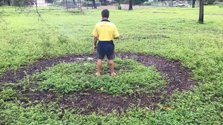 circular formation in grass with a man standing in centre