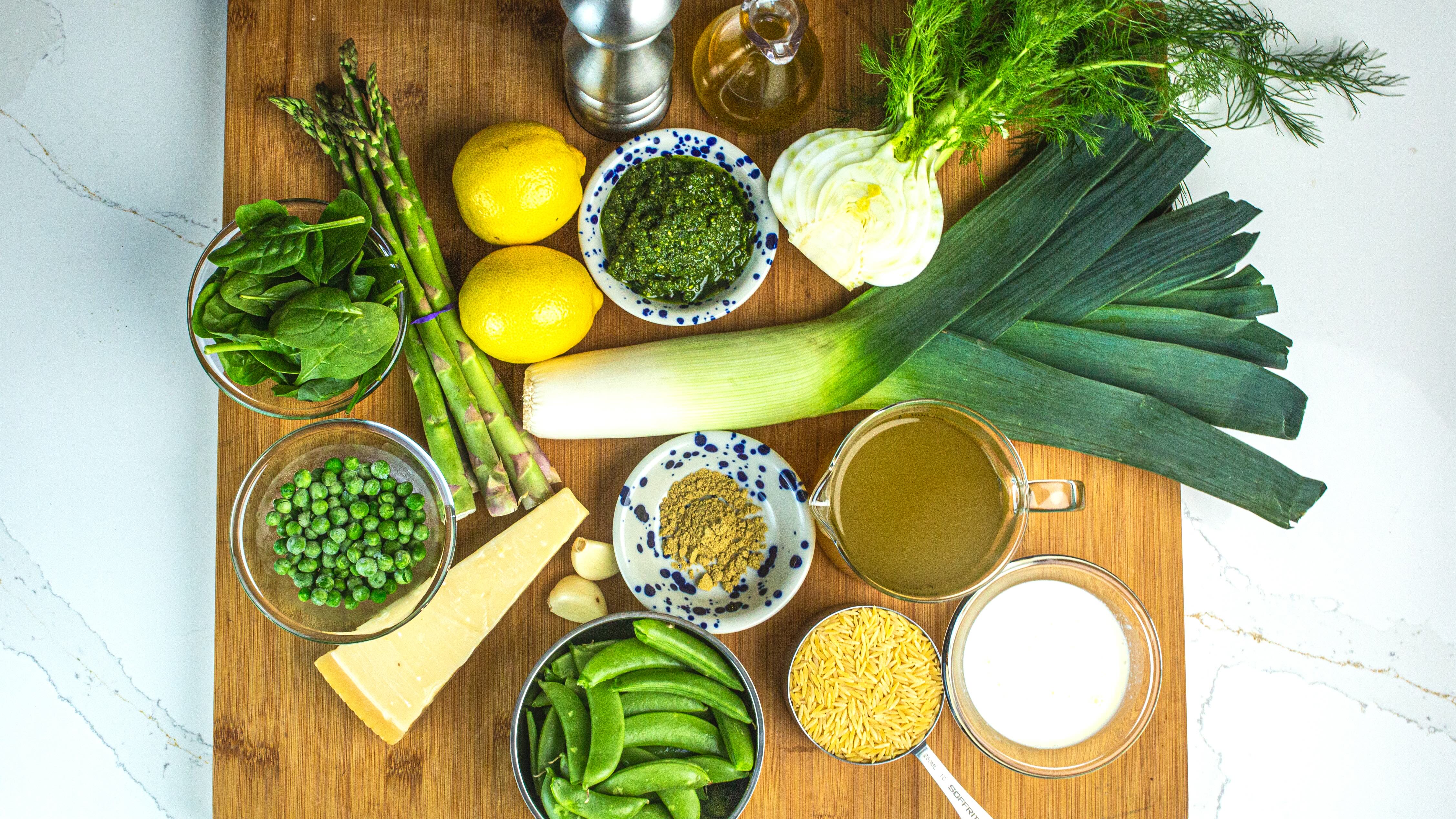 Vegetarian orzo ingredients with asparagus, sugar snap peas, peas, parmesan, stock, fennel and herbs.