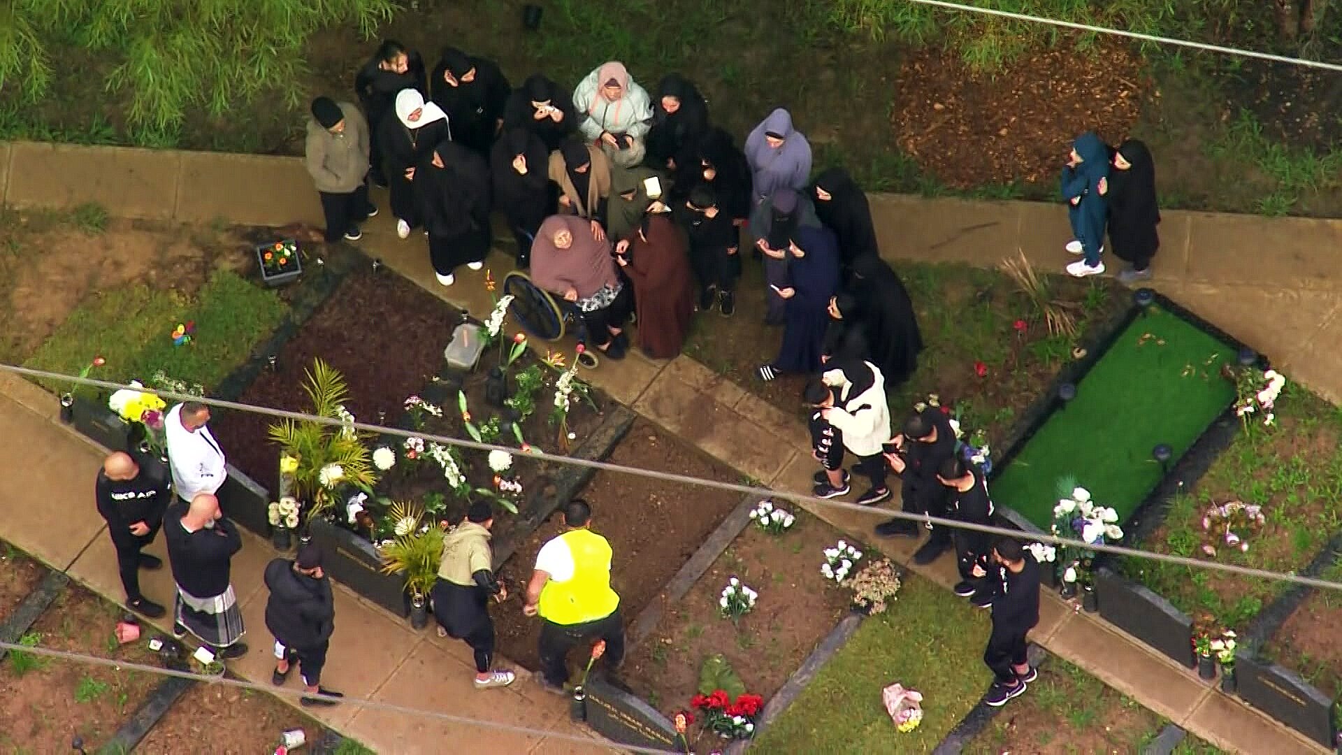people at a burial site at a cemetery