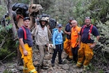 Volunteers from the Tasmania Fire Service and SES with John Elliott and his camels in bushland.