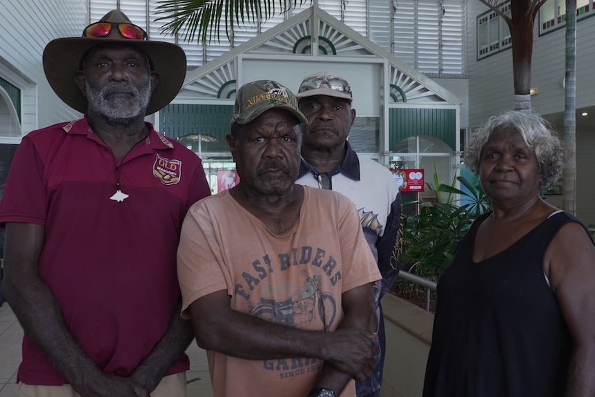 Three Aboriginal men and a woman standing in a hotel foyer area
