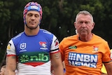 Kalyn Ponga is assisted from the field by a Knights trainer after being concussed in an NRL match against the Wests Tigers.