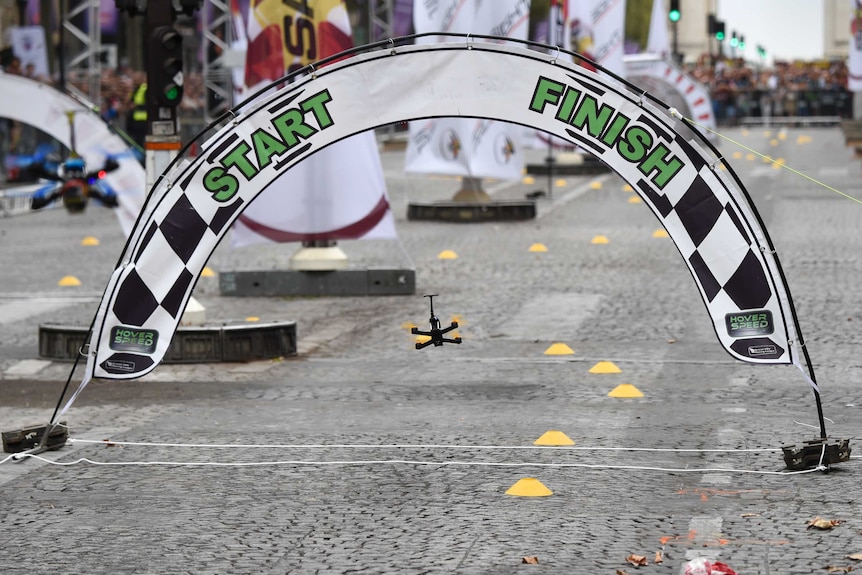 Drone flies between the start/finish flags on Champs-Elysees avenue