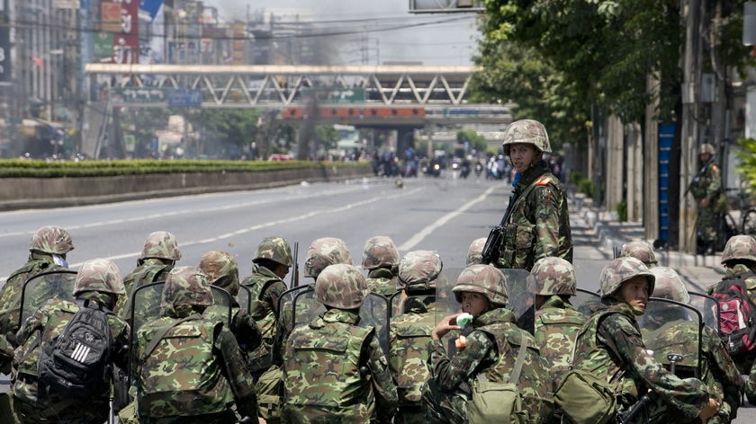 Moving in: Thai soldiers hear gunshots during an operation near the fortified Red Shirt camp