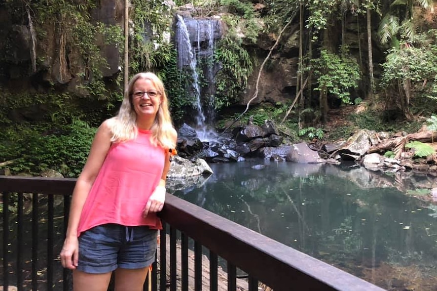 Rachel Smith stands besides a waterfall