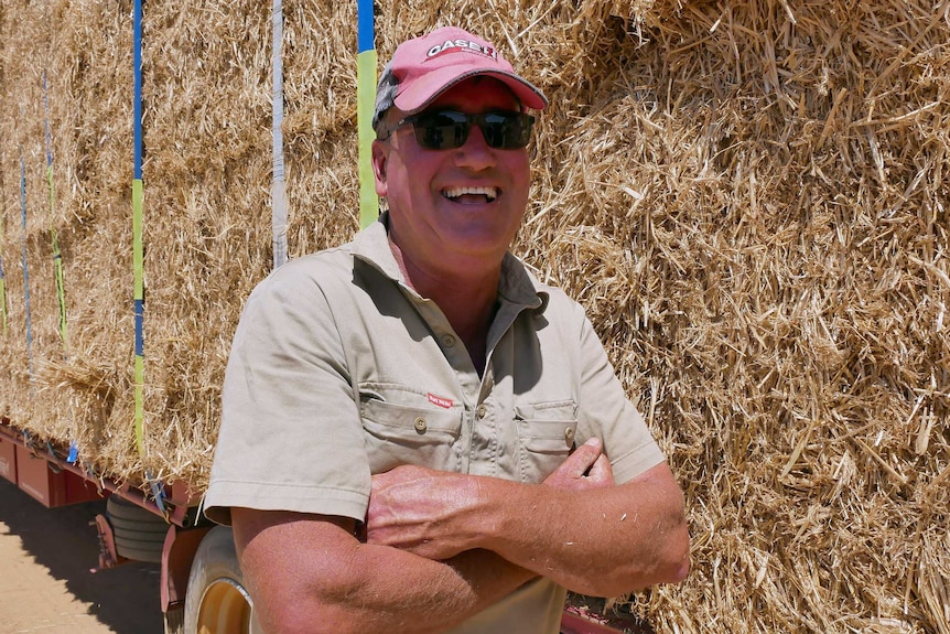 Scaddan farmer Gavin Egan laughing as he stands in front of a truck loaded with hay bales.