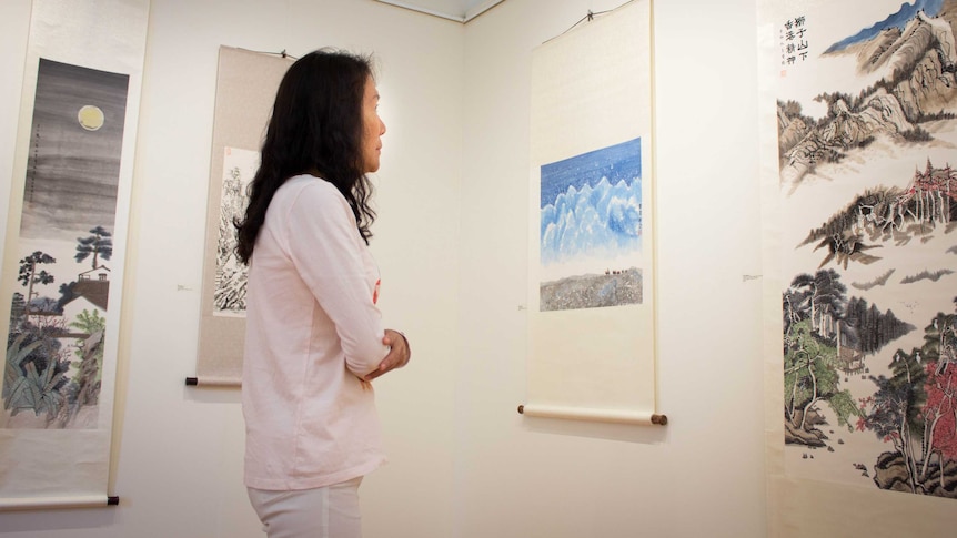 Wong May-po looks at her scrolls hanging on the walls of the East Gippsland Art Gallery