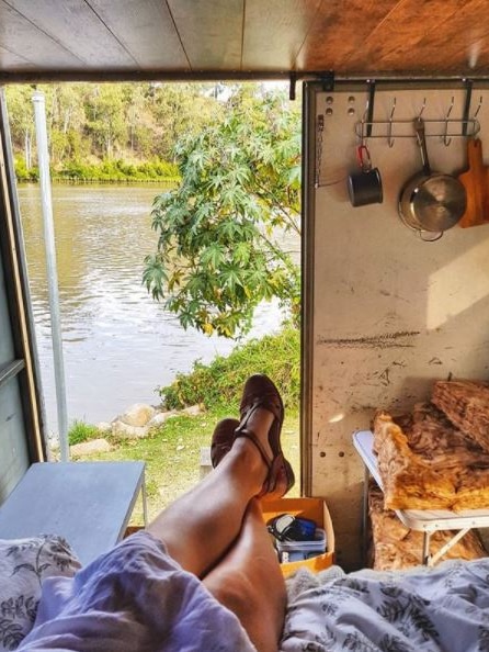 Chrissy Junge in the back of her truck, door open looking at a river