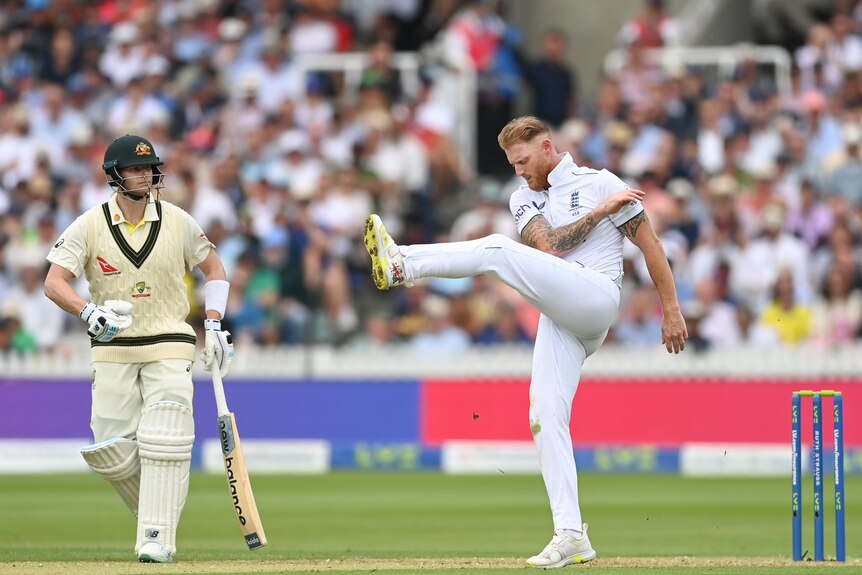 England bowler Ben Stokes kicks out at the ground as Australia batter Steve Smith looks on.