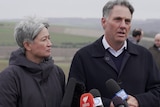 Wong, right, looks at Marles, left, who is speaking. They stand in a field wearing heaving jackets.