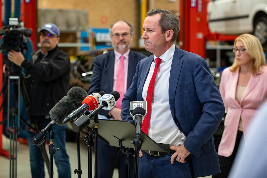 Premier Mark McGowan stands with his hands on his hips and a confused expression in front of microphones.