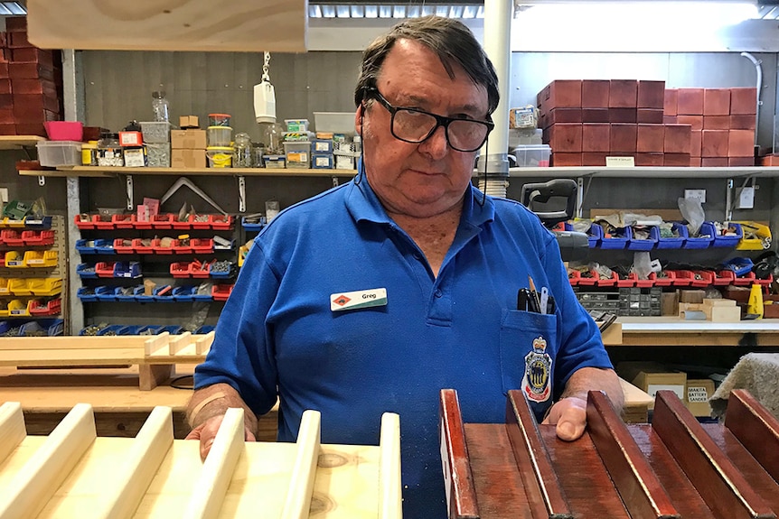 Greg shows off the sausage holders he made at the Veterans Men's Shed