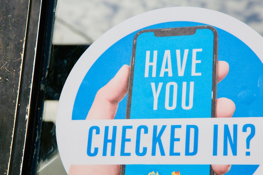 A blue sign shows a hand with a phone and the words 'HAVE YOU CHECKED IN?'.