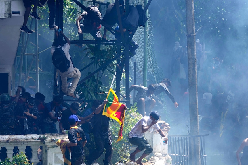 Protesters climb and jump on structures next to Ranil Wickremesinghe's office. 