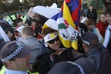 A pro-Tibet protester is detained by police before the start of the Olympic torch relay in Canberra