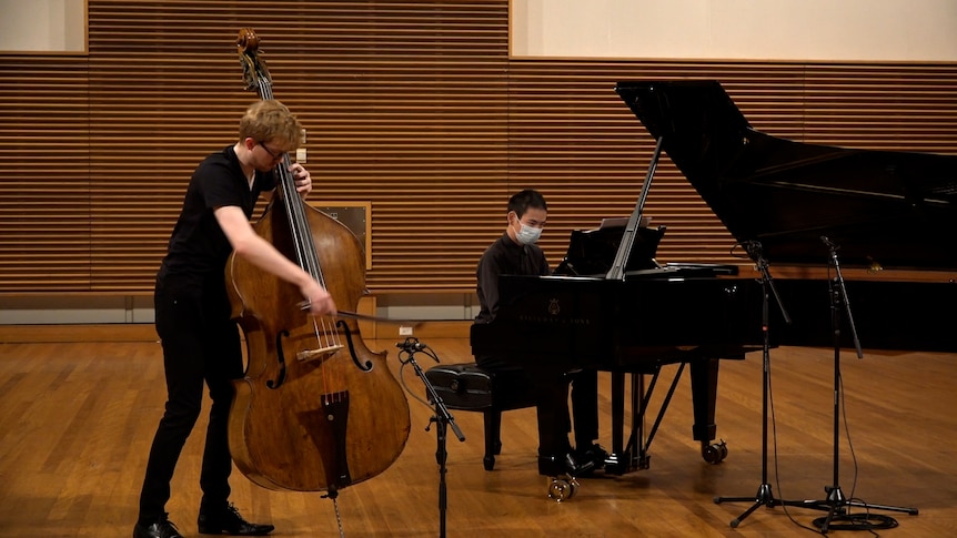 Jason Henery plays double bass standing up while Paul Cheung plays a grand piano