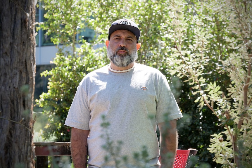 man standing outside with sombre look on his face