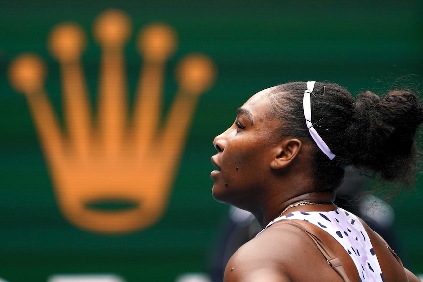 Serena Williams looks up with a crown appearing in the background, in front of her face