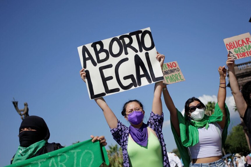 支持堕胎的活动人士举着横幅，上面写着： "合法堕胎" 和 "被迫怀孕是一种折磨"