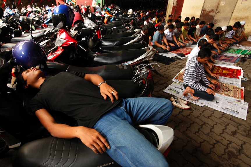 A man sleeps on motorbikes