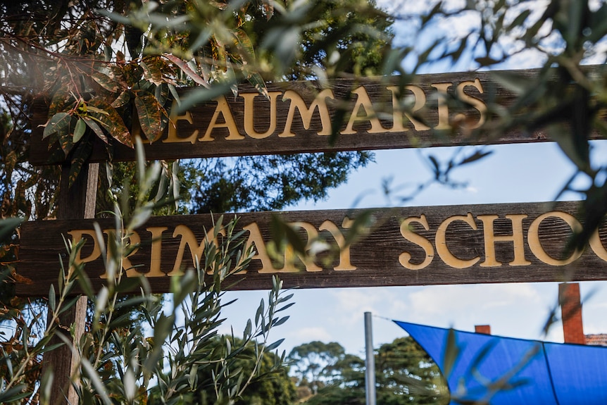 A sign reads 'BEAUMARIS PRIMARY SCHOOL' behind gum leaves.