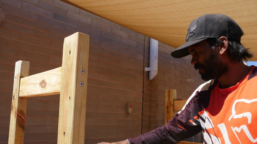 Donovan Huddleston screws in the final nails on the chair he built.