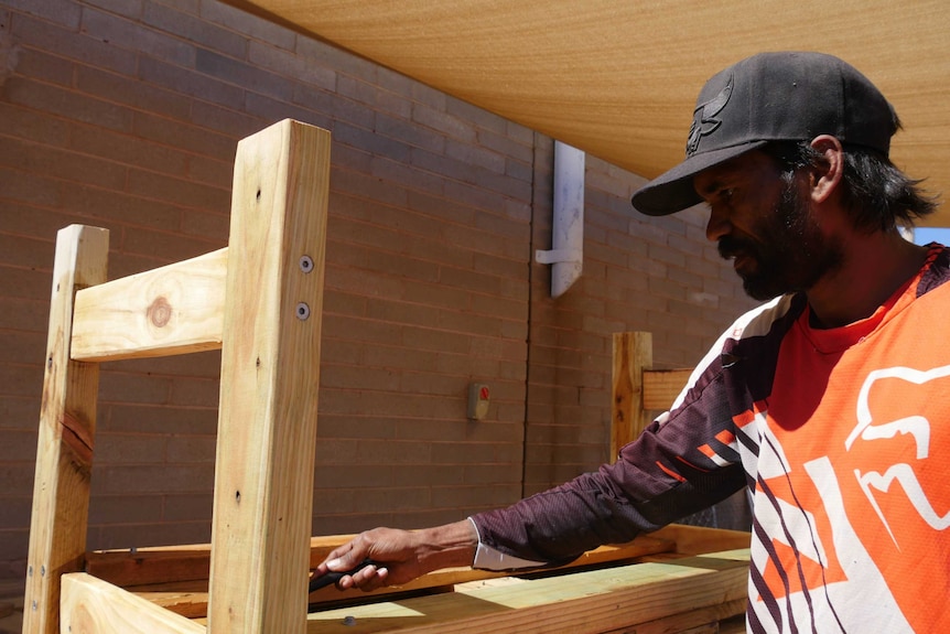 Donovan Huddleston screws in the final nails on the chair he built.