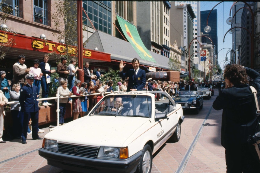 America's Cup skipper John Betrand rides in a car during celebrations of the 1983 victory.