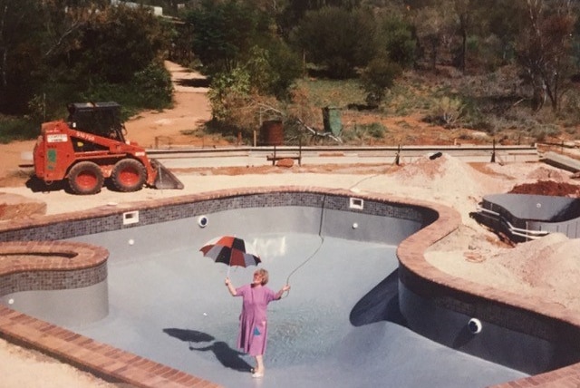 A woman stands in the middle of an empty pool in the shape of Australia.