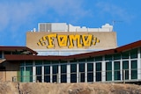 The word FOMO spray painted with yellow paint on a building at the top of the Line of Lode in Broken Hill.