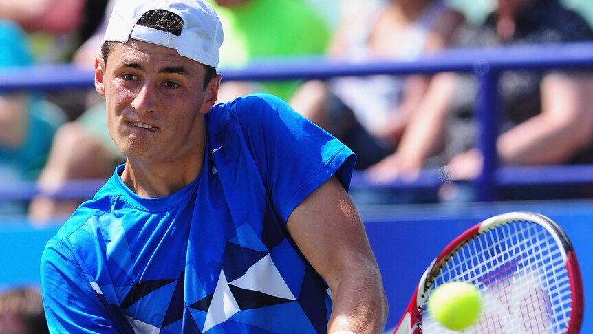 Bernard Tomic plays a backhand during his loss at Eastbourne.