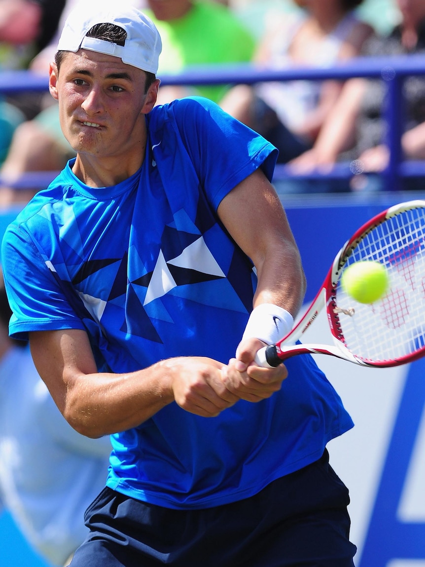 Bernard Tomic plays a backhand during his loss at Eastbourne.