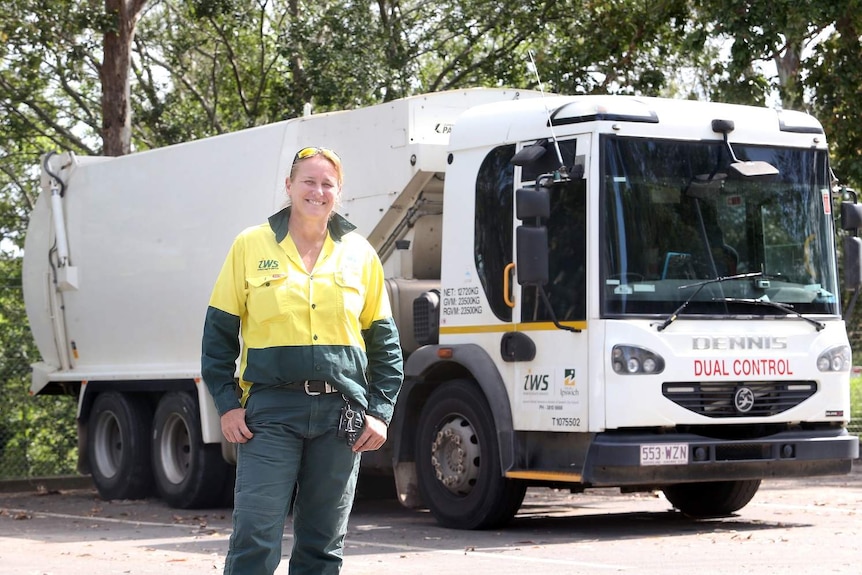 Belinda Janson stands in uniform in front of a garbage truck.