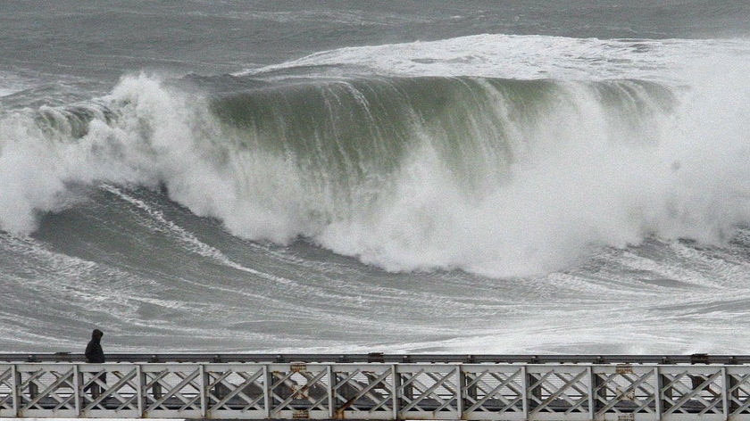 A man watches as waves hit the Atlantic coast