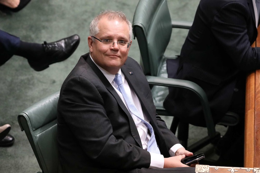 Scott Morrison sits, with an optimistic expression on his face