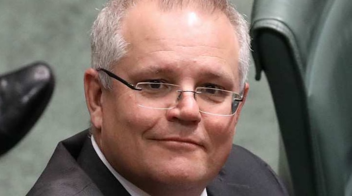 Scott Morrison sits, with an optimistic expression on his face