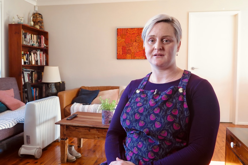 A woman with short blonde hair sitting in a living room