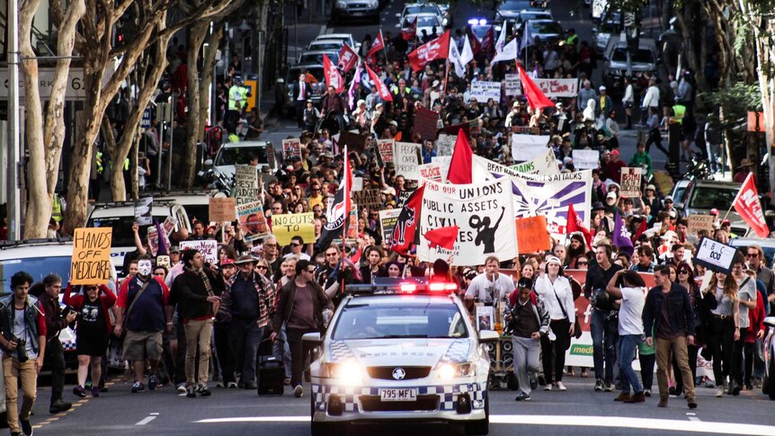 Hundreds of people take to the streets of Brisbane for the Bust the Budget protest march.
