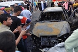 People gather at the site of a deadly car bomb attack in Kut city.