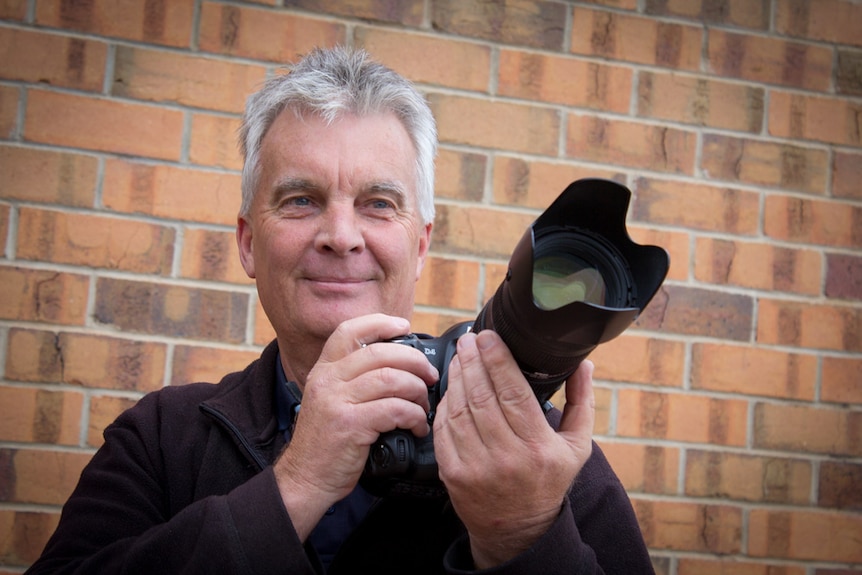 Grant Schwartzkopff holds his camera.