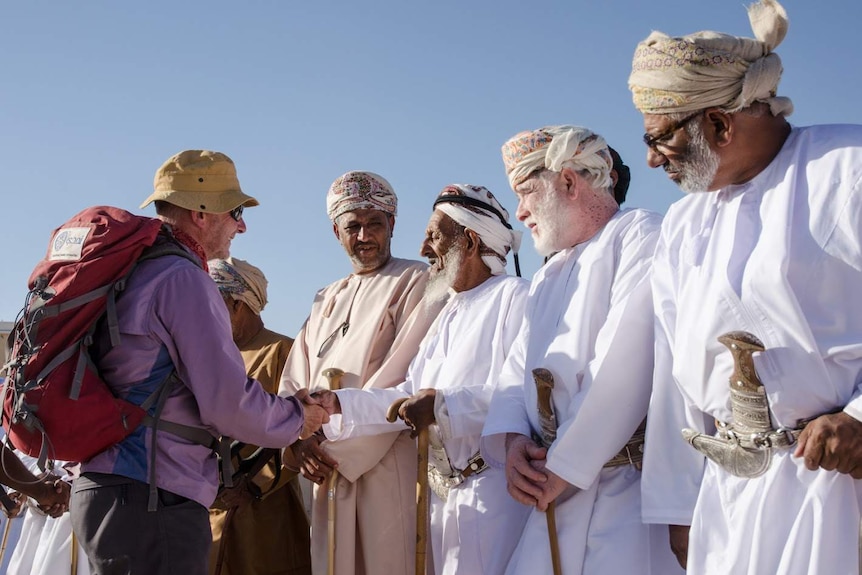 Mark Evans shakes hands with locals in Al Hashman, on the border of the desert