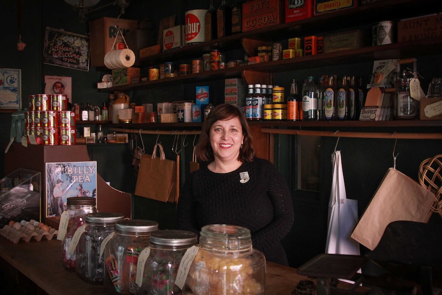 Anna Cossu, curator of Susannah Place Museum, standing at the counter of the old time shop.