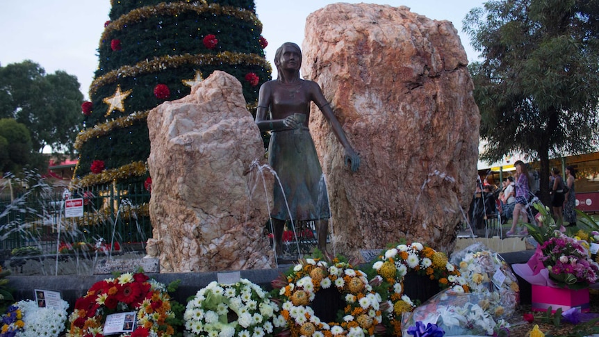 Wreaths surround the statue of St Barbara in central Kalgoorlie.