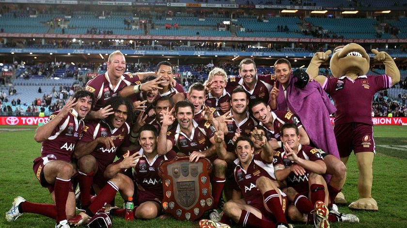 The Maroons celebrate with the trophy after winning State of Origin III