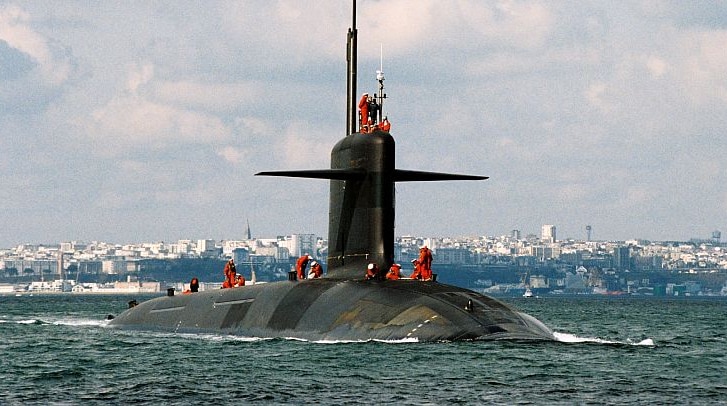 A French nuclear-powered submarine sails through choppy water.