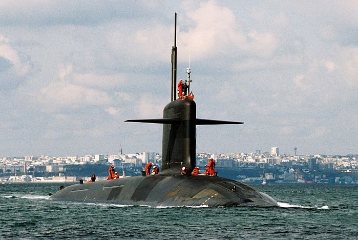 A French nuclear-powered submarine sails through choppy water.