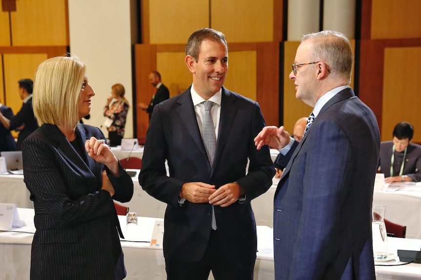 Katy Gallagher, Jim Chalmers and Anthony Albanese smile as they chat among themselves in Parliament House's Great Hall.