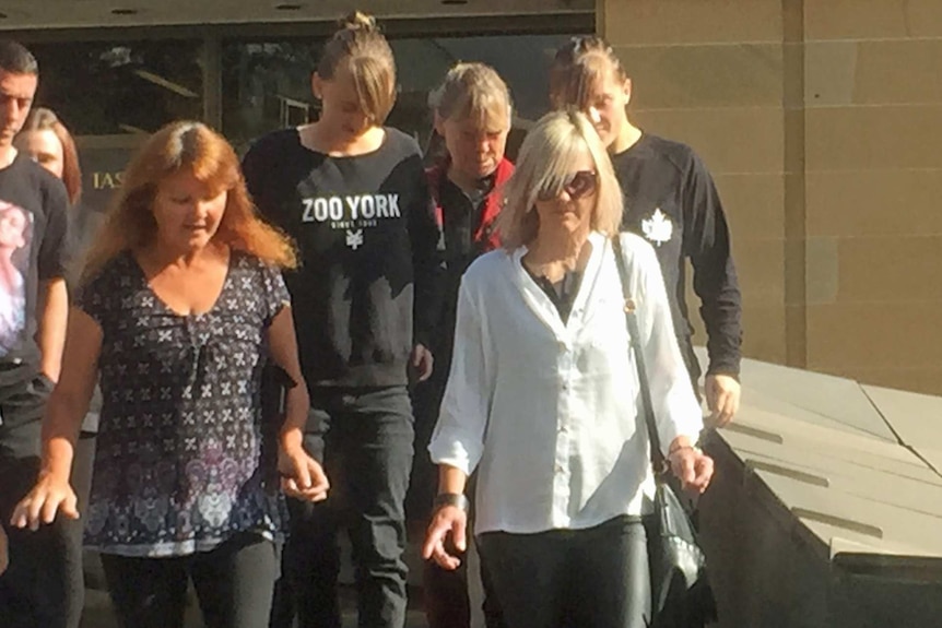 Leesa Jacobs (in white shirt) leaves the Supreme Court in Hobart, surrounded by family and friends.