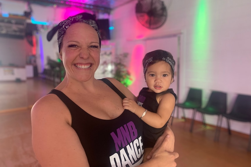 Dance instructor Taleah Lindenberg in dance gear smiling with daughter Presley in matching outfit 
